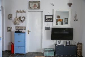 ein Wohnzimmer mit einem TV und einer blauen Kommode in der Unterkunft Villa Petra Sea View Island Brac in Postira