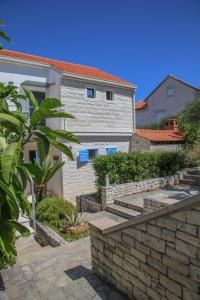 ein Haus mit einer steinernen Mauer und einer Treppe in der Unterkunft Villa Petra Sea View Island Brac in Postira
