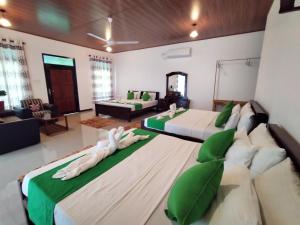 Village Mango Resort Yala في تيساماهاراما: غرفة نوم بسريرين وصالة جلوس