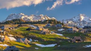 ein Bergdorf mit schneebedeckten Bergen im Hintergrund in der Unterkunft Vacation Station Kamnik in Kamnik