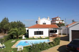a villa with a swimming pool in front of a house at Spacious and family friendly villa at Lisbon coast 