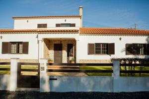 a white house with a fence in front of it at Spacious and family friendly villa at Lisbon coast 