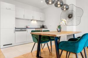 une cuisine avec une table en bois et des chaises vertes dans l'établissement Vienna Chic Residences #Suite 14, à Vienne