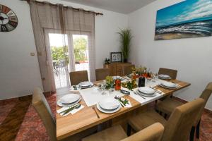 a dining room with a table with chairs and a dining room at Holiday Home Donji Lepuri in Lisičići
