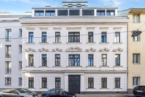 un bâtiment blanc avec des voitures garées devant lui dans l'établissement Vienna Chic Residences #Suite 14, à Vienne