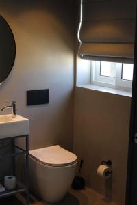 a bathroom with a toilet and a sink and a window at Victoria by Petit Chic in Mellieħa