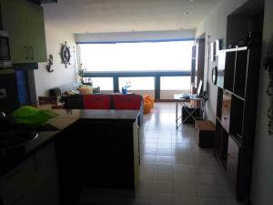 een keuken en een woonkamer met een bank bij Acogedor apartamento con piscina - Bleu Marine Suites in La Guaira
