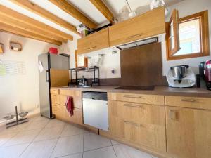 kuchnia z drewnianymi szafkami i lodówką w obiekcie Chalet des Grangettes avec jardin, sauna et Appli Roadbook - Huez w mieście LʼHuez +25 zdjęć