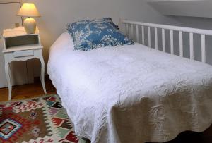 a bedroom with a bed with a blue pillow and a rug at L Heure Bleue in Wezembeek-Oppem