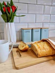 a cutting board with a loaf of bread and a cup of coffee at Rosa House in Darlington
