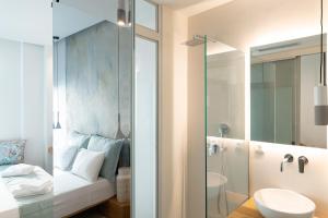 a bathroom with a toilet and a sink and a mirror at Ciel Suites Athens in Athens