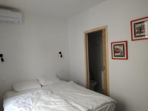 a white bed in a room with a white wall at Port Heaven, a deux pas du port, grand balcon in Port-Vendres