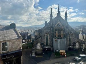 a large stone church with a view of a city at Boutique penthouse apartment with rooftop terrace in Clitheroe