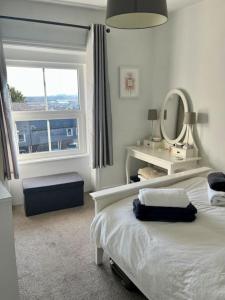 a bedroom with a bed and a mirror and a window at Boutique penthouse apartment with rooftop terrace in Clitheroe