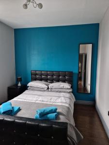 a bedroom with a large bed with a blue wall at Central Northern Quarter Apartment Sleeps Upto 4 in Manchester