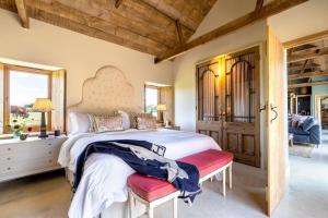 a bedroom with a large bed with a red bench at Cambridge Country Cottages in Cambridge