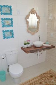 uma casa de banho com um WC, um lavatório e um espelho. em La Maison Brasiliana B&B em Foz do Iguaçu