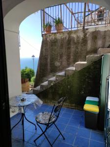 a patio with a table and a chair and stairs at Rifugio Stellato in Conca dei Marini