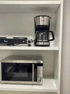 a microwave on a shelf with a blender on it at The Love Nest at Central Athens Kolonaki in Athens