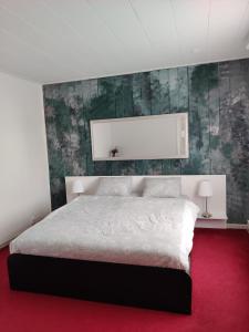 a bedroom with a white bed and a red carpet at Amrai in Ventspils