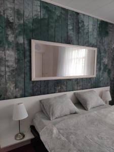 a bedroom with a large mirror above a bed at Amrai in Ventspils