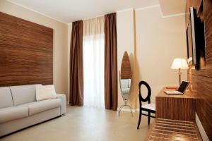 ein Wohnzimmer mit einem Sofa und einem Schreibtisch mit einem Laptop in der Unterkunft S Hotel in San Giovanni Teatino