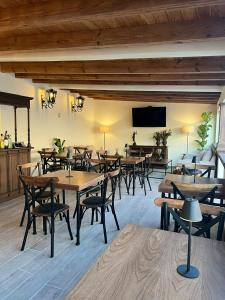 een restaurant met houten tafels en stoelen en een flatscreen-tv bij Hotel Boutique Rincón de Luna in San Juan del Río