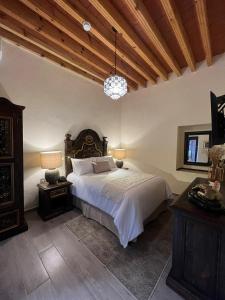 a bedroom with a large bed and a wooden ceiling at Hotel Boutique Rincón de Luna in San Juan del Río