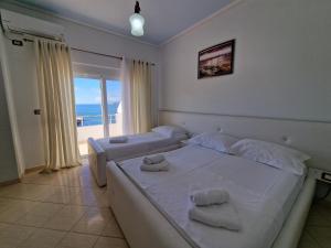 a bedroom with two beds and a view of the ocean at Hotel Artur in Ksamil