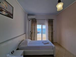 a bedroom with a bed and a view of the beach at Hotel Artur in Ksamil