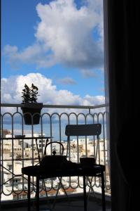 a balcony with a table and a view of the ocean at Victoria by Petit Chic in Mellieħa