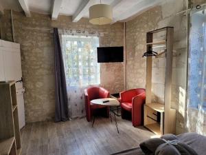 salon z czerwonymi krzesłami i stołem w obiekcie Gîte 3* Piscine Spa entre ZOO BEAUVAL FUTUROSCOPE CHATEAUX LOIRE w mieście Sainte-Maure-de-Touraine