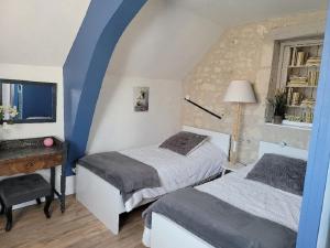 sypialnia z dwoma łóżkami, biurkiem i oknem w obiekcie Gîte 3* Piscine Spa entre ZOO BEAUVAL FUTUROSCOPE CHATEAUX LOIRE w mieście Sainte-Maure-de-Touraine