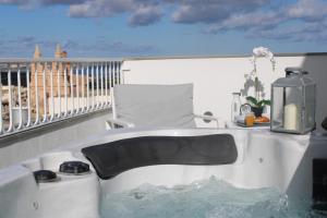 a bath tub with water in it on a balcony at Victoria by Petit Chic in Mellieħa