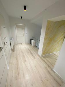 an empty room with a wooden floor and a mirror at Apartman M&M in Žilina