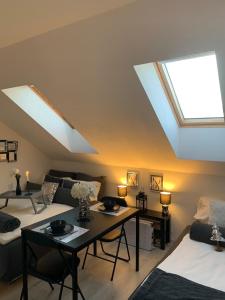 a living room with skylights and a table and a couch at Apartment Mansarda in Maribor
