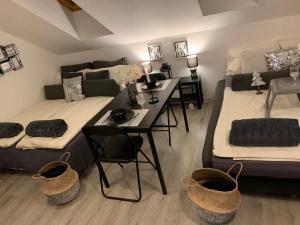 a bedroom with two beds and a desk and a table at Apartment Luna in Maribor