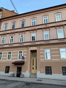 a large brown building with a yellow door at Apartment Luna in Maribor