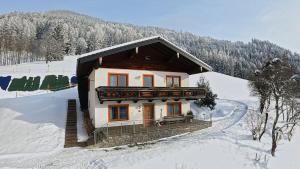 una pequeña casa en la nieve en las montañas en Ferienhaus Englbrecht, en Krispl