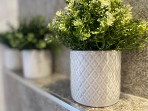 un vase blanc rempli de fleurs sur une étagère dans l'établissement Suite del Ponte, à Varèse