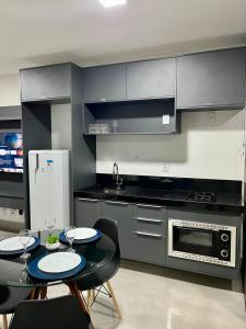 a kitchen with a table and chairs and a microwave at Estúdio no 27º Andar com Vista p/ Av. Afonso Pena in Campo Grande