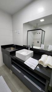baño con lavabo y espejo grande en Estúdio no 27º Andar com Vista p/ Av. Afonso Pena, en Campo Grande