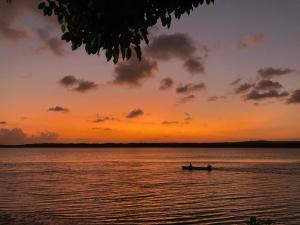 two people in a boat on the water at sunset at Verão on in Cabedelo