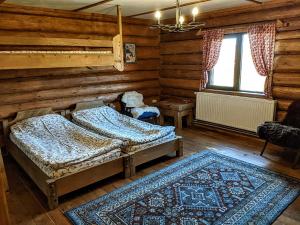 1 dormitorio con 2 camas y alfombra en Vasanna en Kosiv