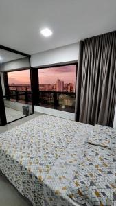 a bedroom with a bed with a view of a city at Estúdio no 27º Andar com Vista p/ Av. Afonso Pena in Campo Grande