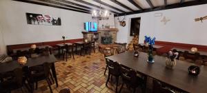 a restaurant with tables and chairs and a fireplace at Dikke Vriend , herberg & taverne in Chiny