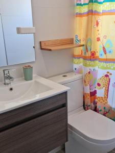 ein Badezimmer mit einem WC, einem Waschbecken und einem Duschvorhang in der Unterkunft Departamento Nuevo en Papudo 3D-2B in Papudo
