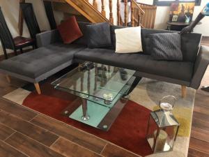 - un salon avec un canapé noir et une table en verre dans l'établissement BELLE VILLA PROCHE BORD DE MER, à Ngaparou