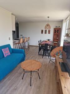 ein Wohnzimmer mit einem blauen Sofa und einem Tisch in der Unterkunft Departamento Nuevo en Papudo 3D-2B in Papudo