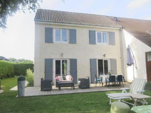 a house with a deck with chairs and a patio at Demeure de charme paisible in Villepinte